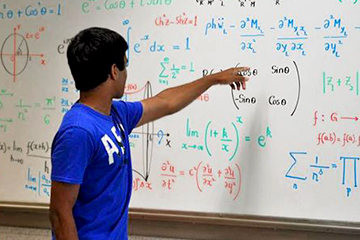 Young Man in Front of Board filled with Equations