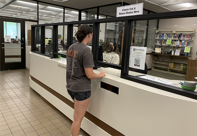 Student borrowing from the Library at first floor checkout desk