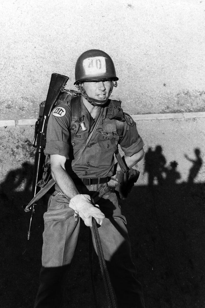 A student in the ROTC program practices scaling down a wall in the 1970s.