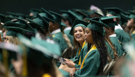 Students in their caps and gowns at commencement ceremonies.